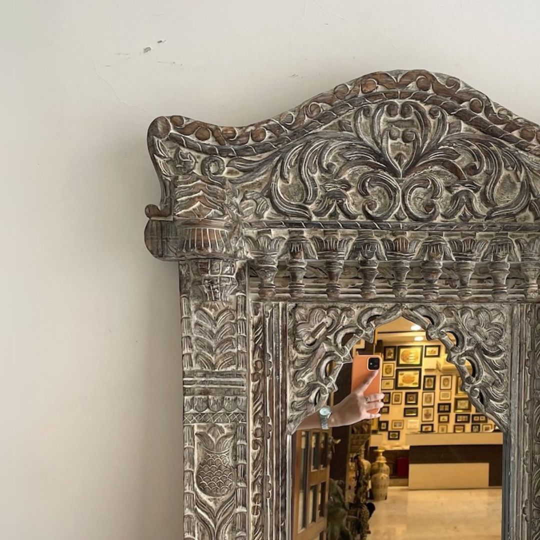 "Gold-framed jharokha mirror with detailed antique-style carvings, offering an elegant blend of Indian heritage and modern decor trends