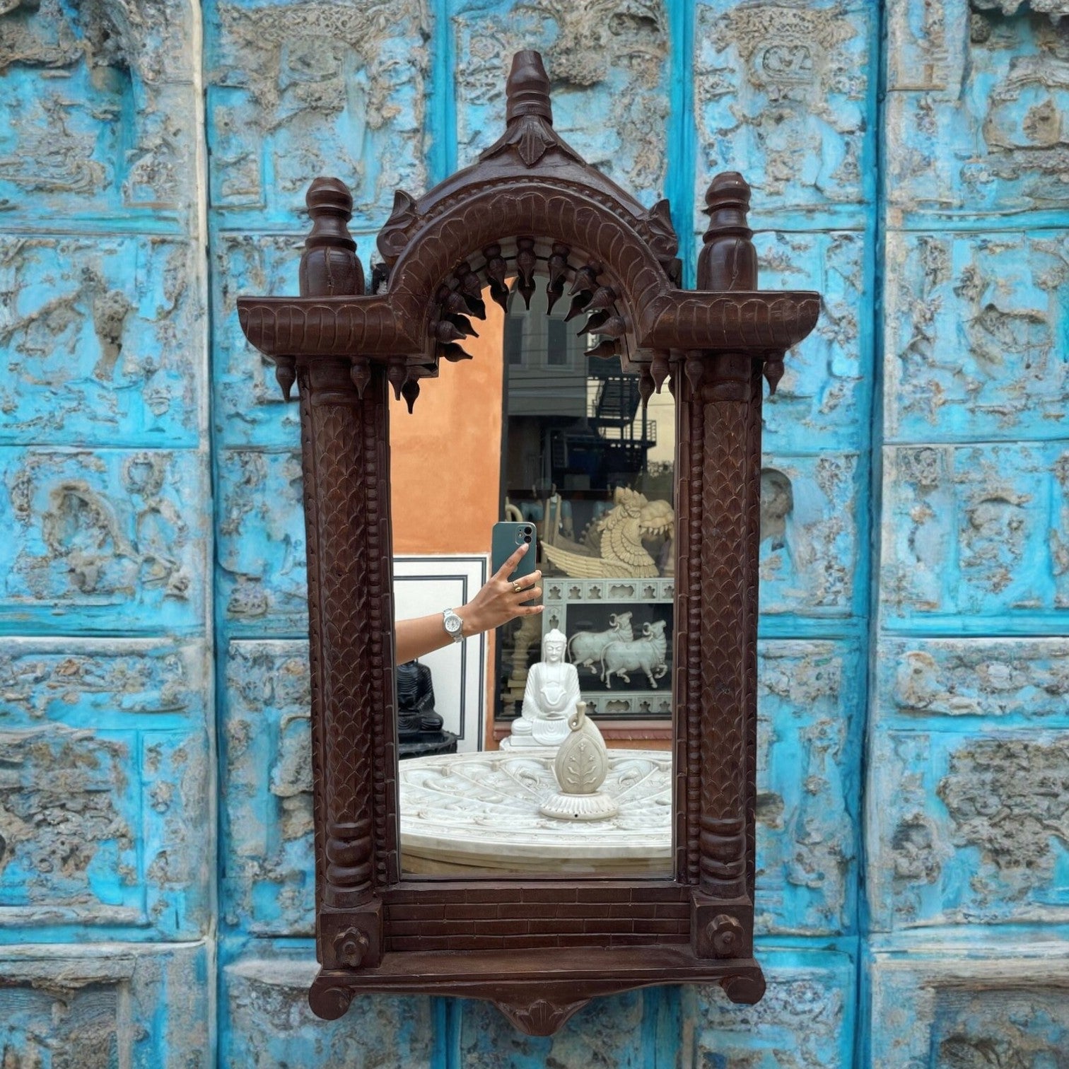 A large jharokha mirror frame featuring a big vintage mirror with intricate wood carvings, perfect for adding antique charm to living room or hallway decor.
