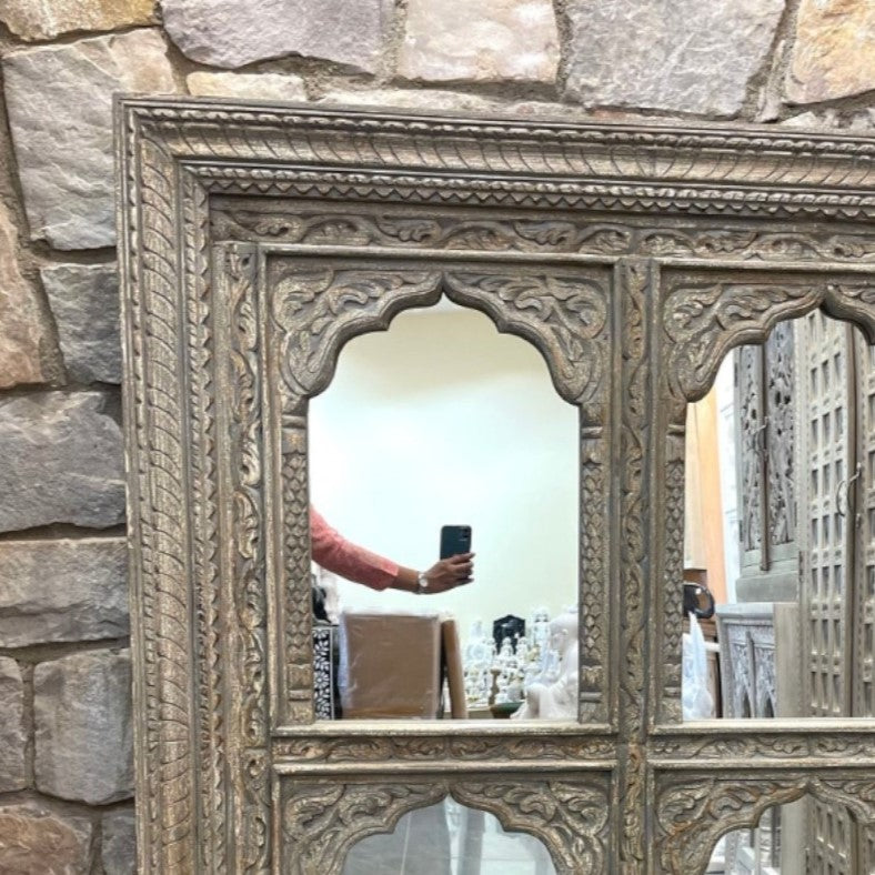A beautifully crafted jharokha mirror with a large vintage mirror, perfect for creating a stunning focal point in your living space. This carved mirror features antique brass accents and a gold frame, combining both modern and traditional elements for an eye-catching addition to vintage home decor