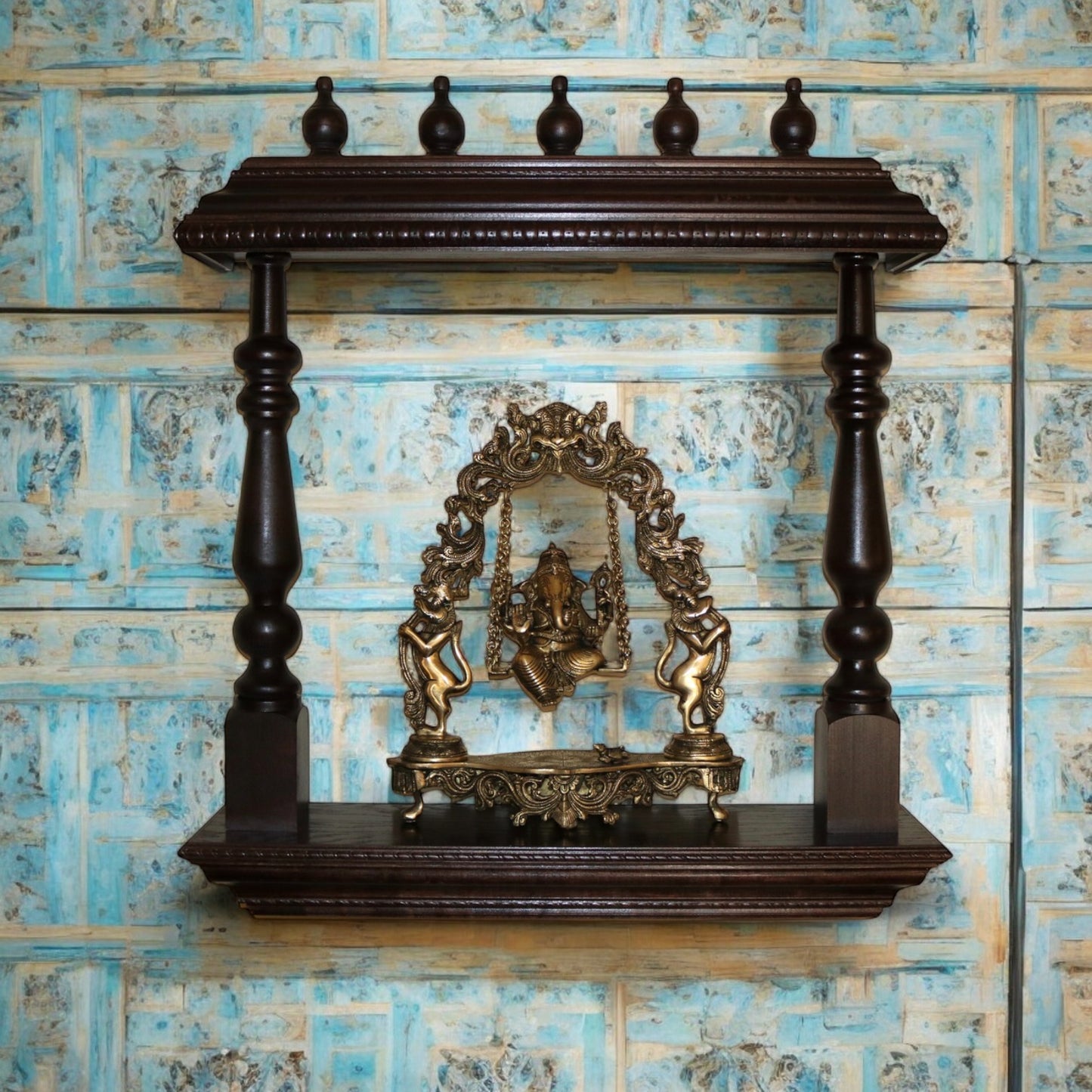 Handcrafted wooden wall shelf with intricate carvings and Ganesha idol, perfect for home temple decor Rustic wooden wall-mounted bookshelf featuring a decorative Ganesha idol and ample space for storing books, displaying souvenirs, or organizing essentials. This versatile shelf fits seamlessly into a variety of interior styles, from vintage and bohemian to contemporary minimalism