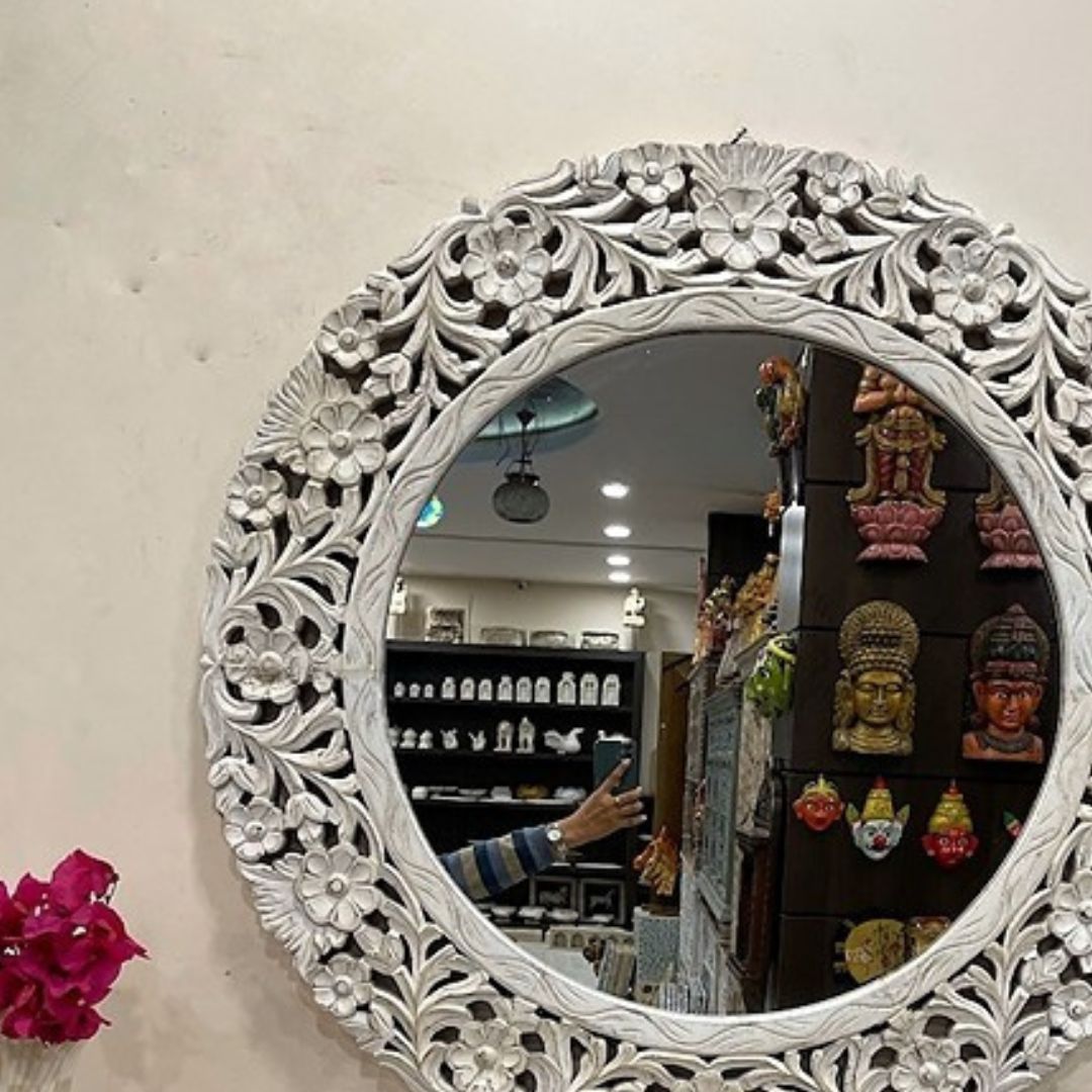 Big vintage mirror framed with intricate Jharokha-inspired woodwork, creating a stunning focal point for antique bathroom or dressing room decor.