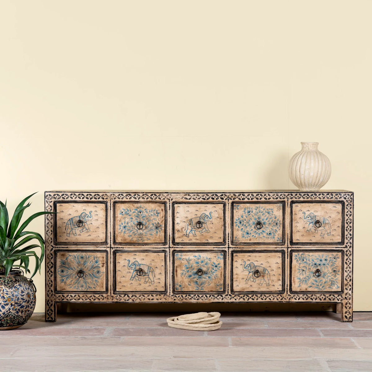 Decorative wooden cabinet with intricate carvings and patterns on a light background