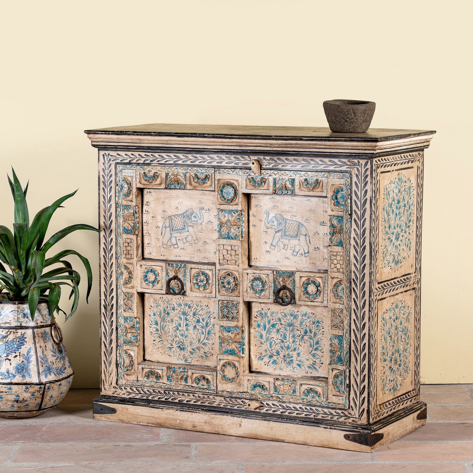 Decorative wooden cabinet with intricate carvings on a beige background