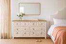 Beige dresser with mirror in a bedroom setting