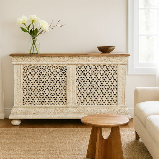 Decorative console table with intricate carvings in a living room setting.