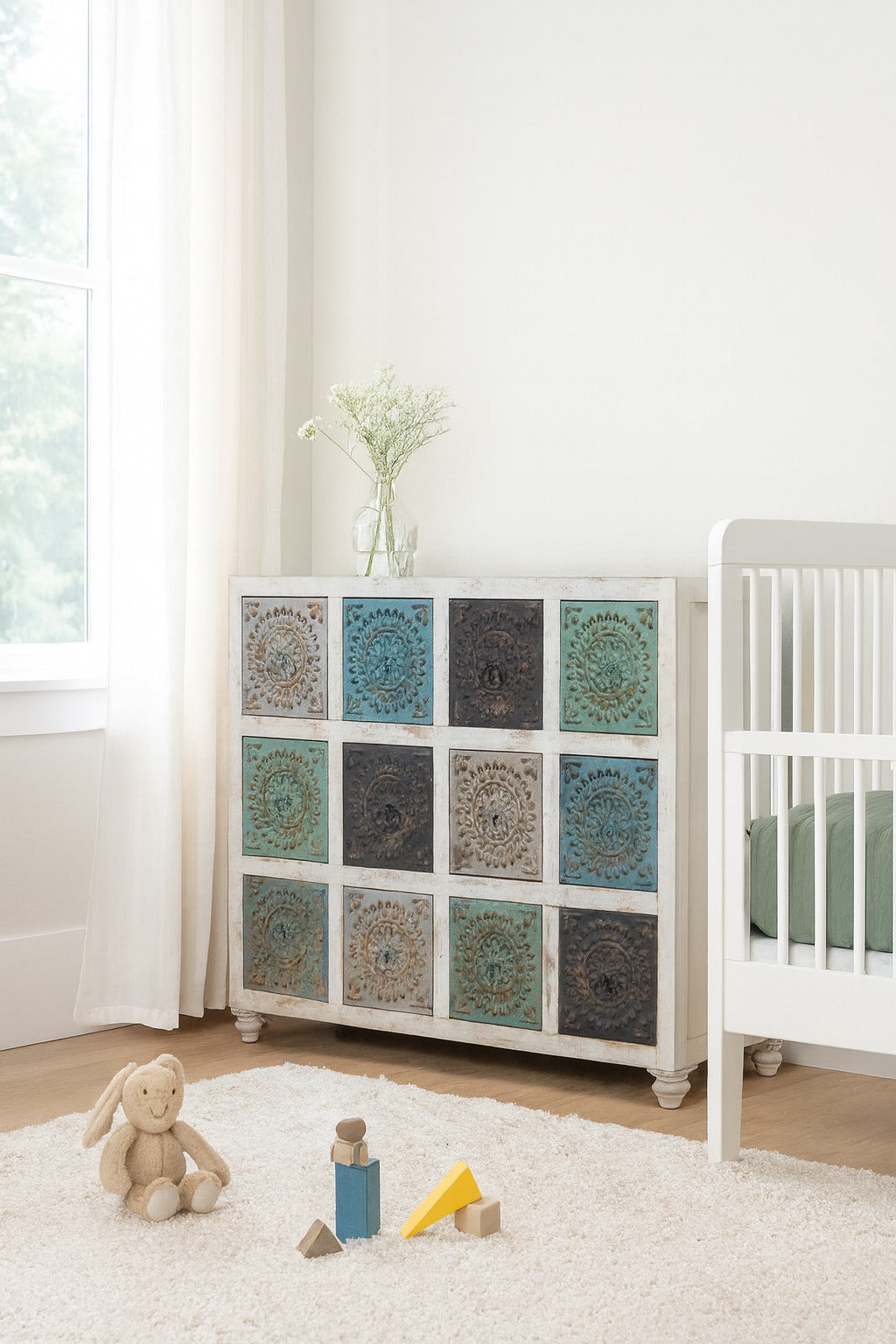 Children's room with a cabinet featuring decorative panels and a crib.